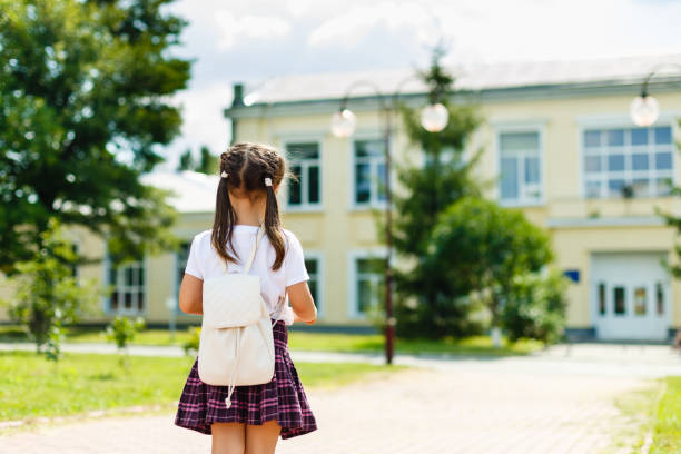 istock little girl with a backpack going to school. back view 889026598