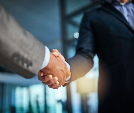 Cropped shot of two businessmen shaking hands in a modern office