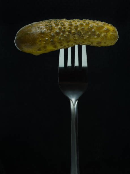 pickle on a fork shot on a black background pickle on a fork shot on a black background. mark goodson screening room stock pictures, royalty-free photos & images