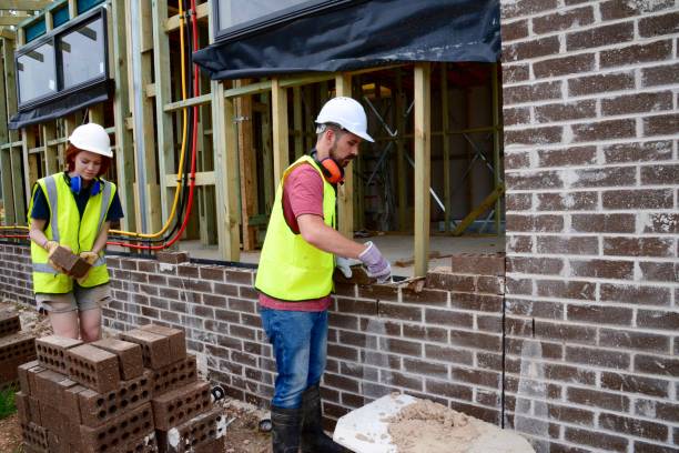 istock SYD112017 Male and female construction workers moving bricks and building 889059532