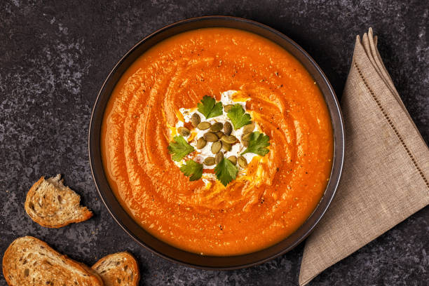istock Pumpkin and carrot soup with cream, seeds and parsley. 889062448