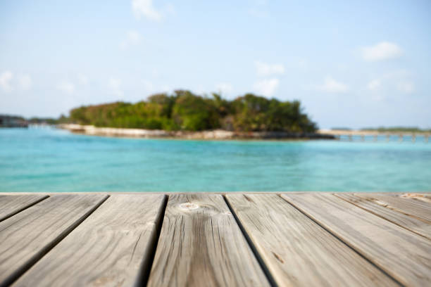 istock Empty white wood surface over blur blue ocean lagoon and sky and tropical for product placement and display 889068592