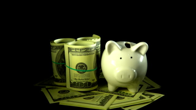 Piggy bank and dollar bills turn on a black background