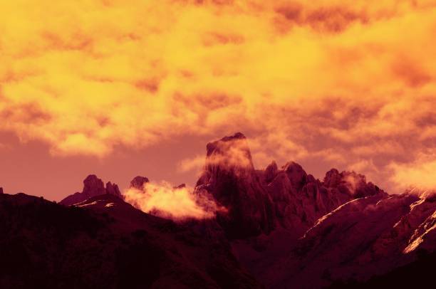 Beautiful landscape formed by high mountains and a spectacular sky over a green meadow.