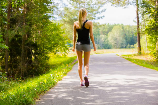 sporty woman seen from the front walking down the street