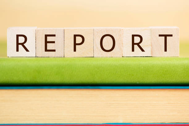 istock Report word built with letter cubes on green book 889086614