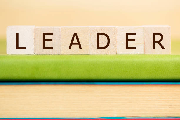Leader word built with letter cubes on green book