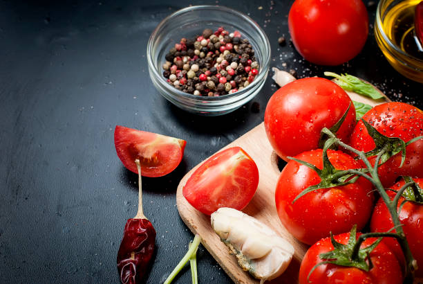 istock Black rustic tabletop with branch of tomatoes and herbs, top view 889094916