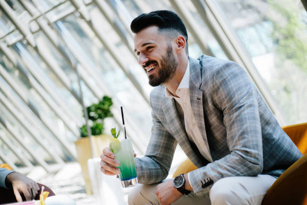 istock Businessman drinking cocktail in hotel lobby 889095452
