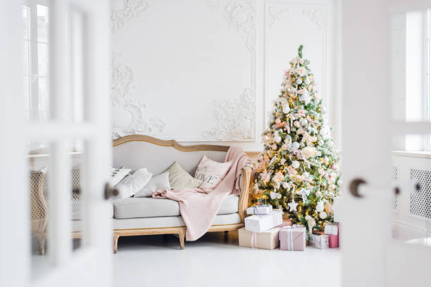 istock Christmas tree with a white sofa in a white room through the doorway 889115074