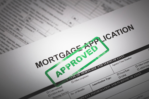 A stock photo of a Mortgage application form with a green \