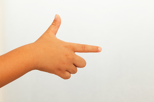 A child's hand pointing in the direction on white background