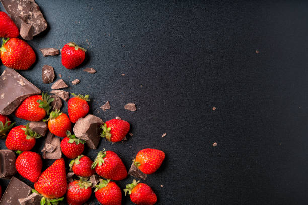 istock Strawberries and chunk chocolate on blackboard 889129008