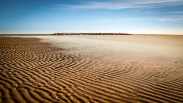 Tidal linhas na areia ao longo da praia. - foto de acervo