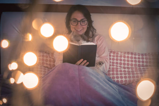 istock Beautiful woman reading in with her cute dog 889136372
