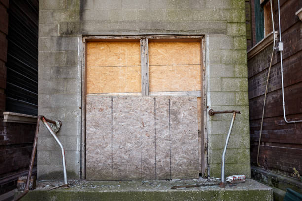 istock Old boarded up door to an abandoned business 889146936