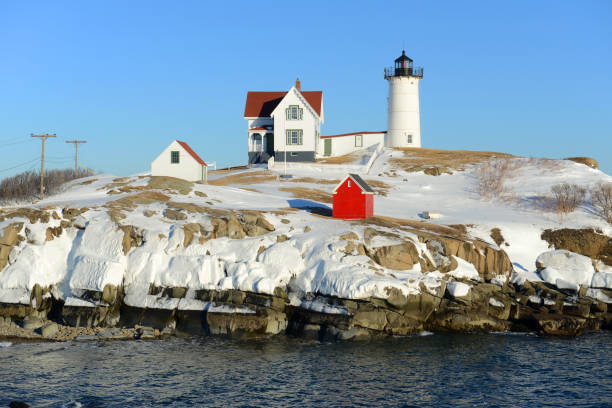 маяк мыса неддик в олд-йорк-виллидж зимой, штат мэн, сша - maine lighthouse winter ice стоковые фото и изображения