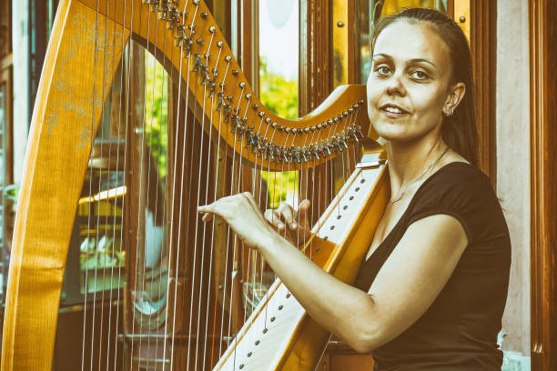 istock a beautiful girl plays a harp in a public 889158010