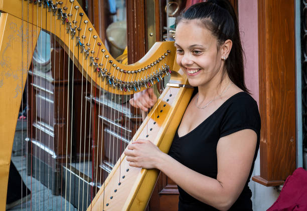 istock a beautiful girl plays a harp in a public 889158396