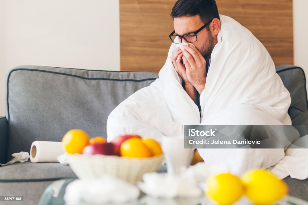 Sickness Young man suffering from cold at home Allergy Stock Photo