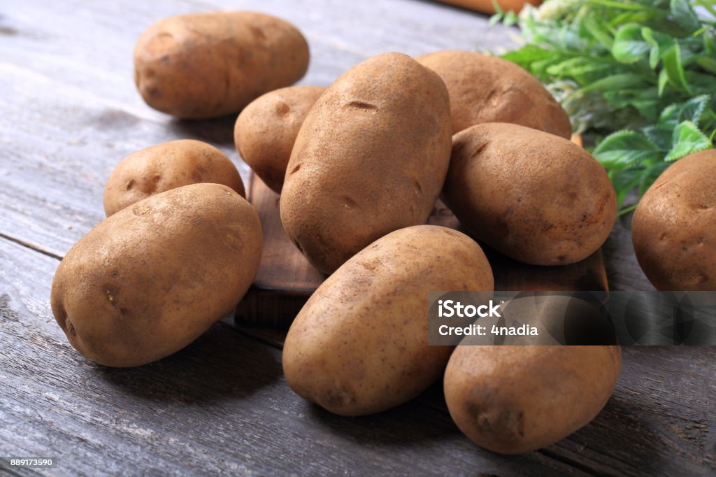 Potatoes on wooden table Prepared Potato Stock Photo