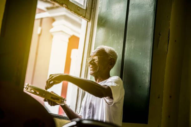 senior brasiliano che gioca a samba in casa - samba (brasile) foto e immagini stock