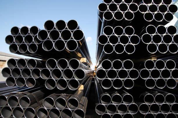 stapel von stahlrohren gegen blauen himmel - tube pipeline metal steel stock-fotos und bilder