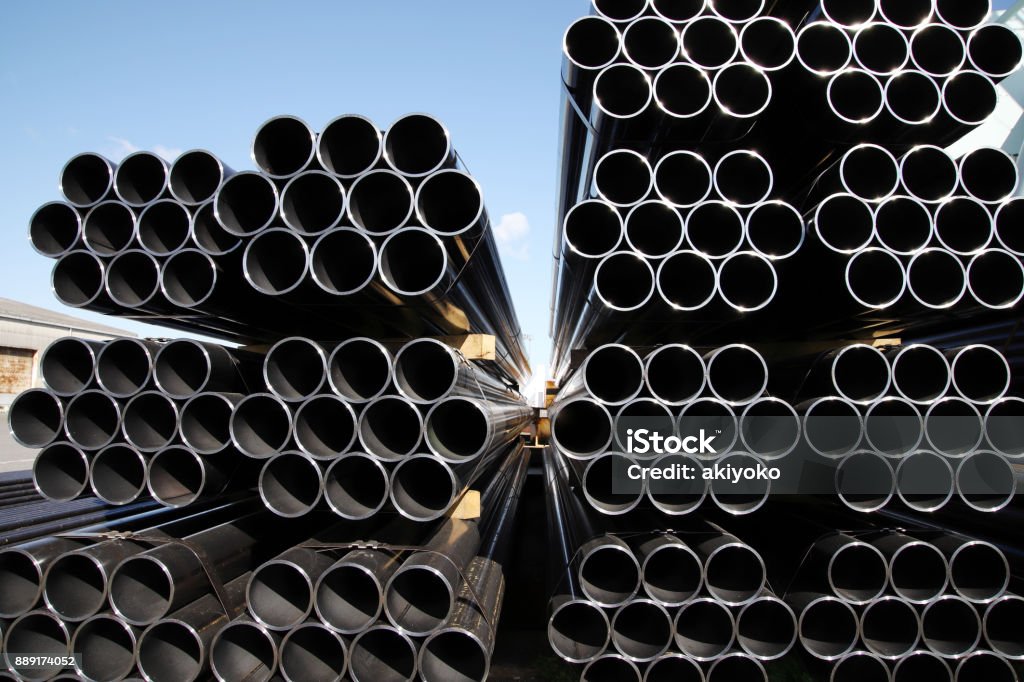 pila de tubos de acero contra el cielo azul - Foto de stock de Acero libre de derechos