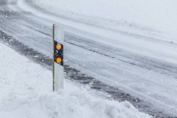 odbłyśnik post na zaśnieżonej śliskiej, lodowatej białej śnieżnej zimowej drodze - car winter road reflector snow zdjęcia i obrazy z banku zdjęć