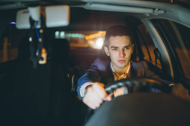 istock Angry businessman driving car at night 889204074