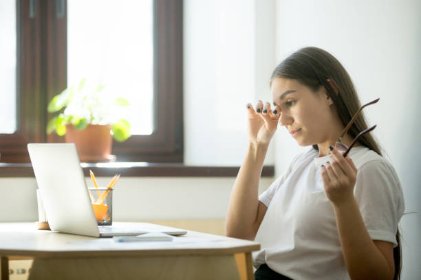 tired businesswoman holding glasses and rubbing eyes in home office - staring imagens e fotografias de stock