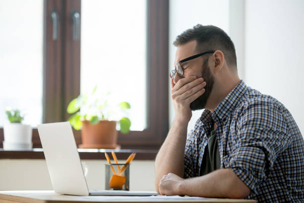 istock Tired sleepy manager in glasses yawning at work in office 889206814
