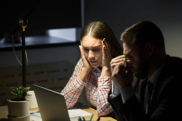 istock Stressed tired coworkers looking at laptop at night with depression 889208354