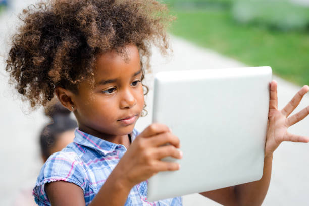 istock Cute preschool girl using digital tablet 889216232