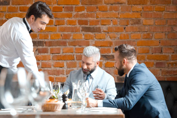 partner commerciali che pranzano al ristorante - restaurant waiter table wait staff foto e immagini stock