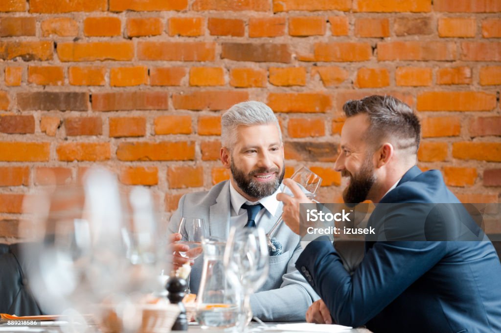 Two businessman having a successful meeting at restaurant Two businessman sitting a restaurant table and smiling. Business partners having a successful meeting at restaurant. Business Meeting Stock Photo
