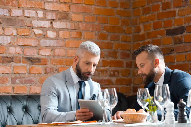 istock Businessmen discussing business project in restaurant 889218804