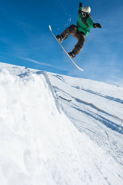 istock Snowboarder jumping against blue sky 889223042