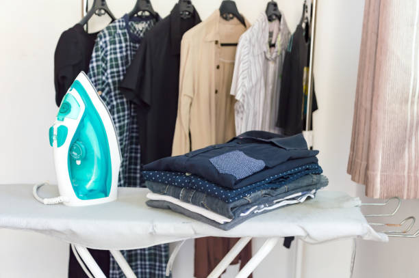 ironing clothes on ironing board,pile of clothes in the white room.ironing concept. - appliance living room domestic room lifestyles imagens e fotografias de stock