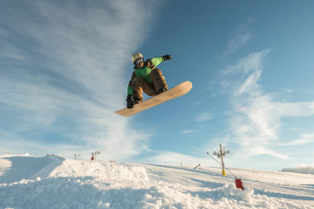 istock Snowboarder jumping against blue sky 889223248
