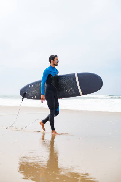 istock Young male surfer wearing wetsuit 889223370