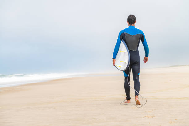 istock Young male surfer wearing wetsuit 889225520