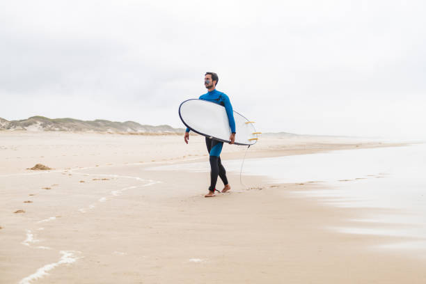 istock Young male surfer wearing wetsuit 889225542