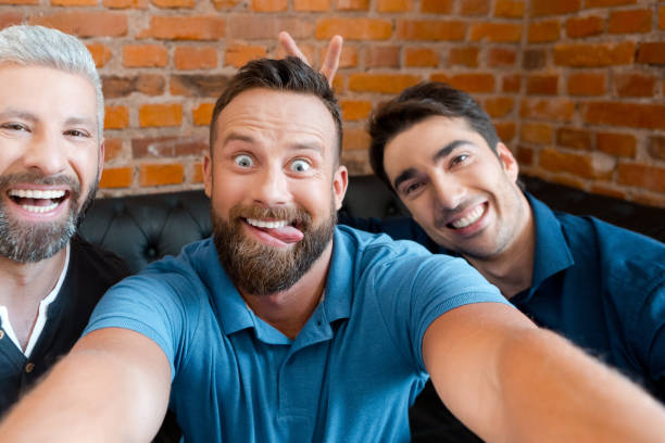 istock Friends making funny faces and taking selfie in the pub 889225544