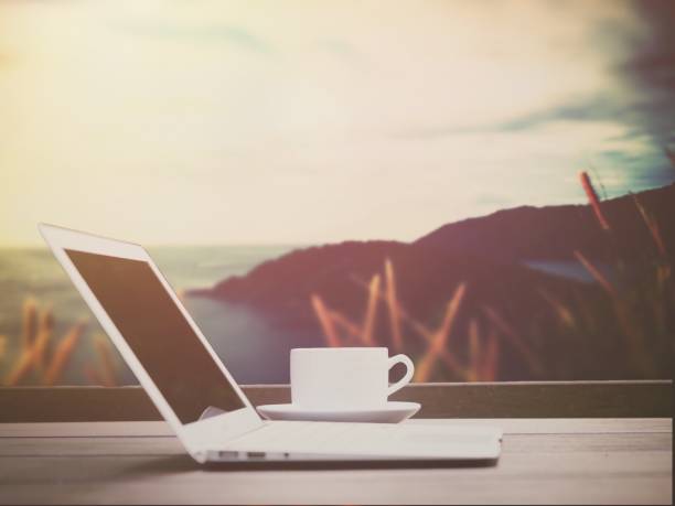 istock Modern laptop with coffee cup on wood table and landscape natural view 889225548