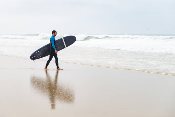 istock Young male surfer wearing wetsuit 889225586