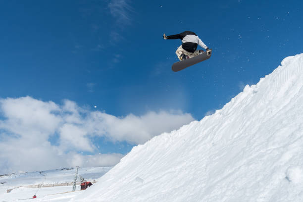 istock Snowboarder jumping against blue sky 889228790
