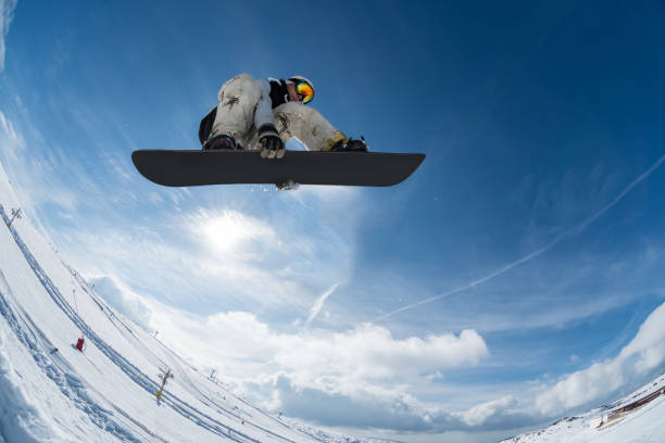 istock Snowboarder jumping against blue sky 889228854