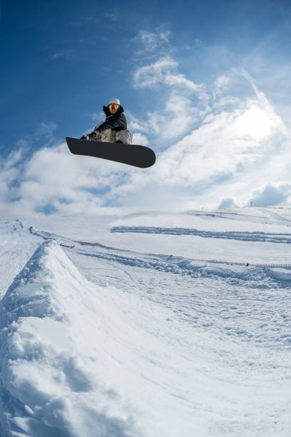 istock Snowboarder jumping against blue sky 889228874