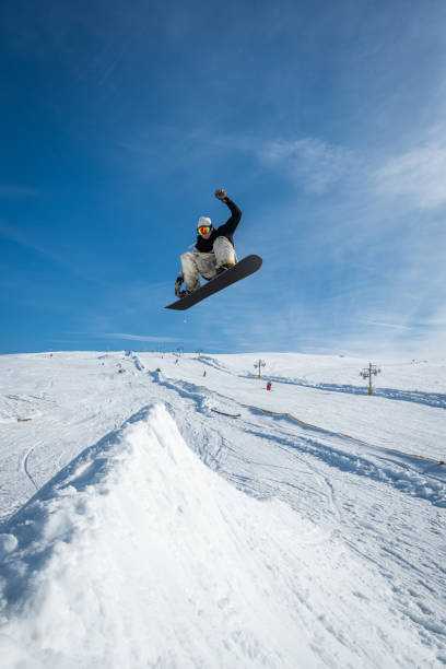 istock Snowboarder jumping against blue sky 889231038